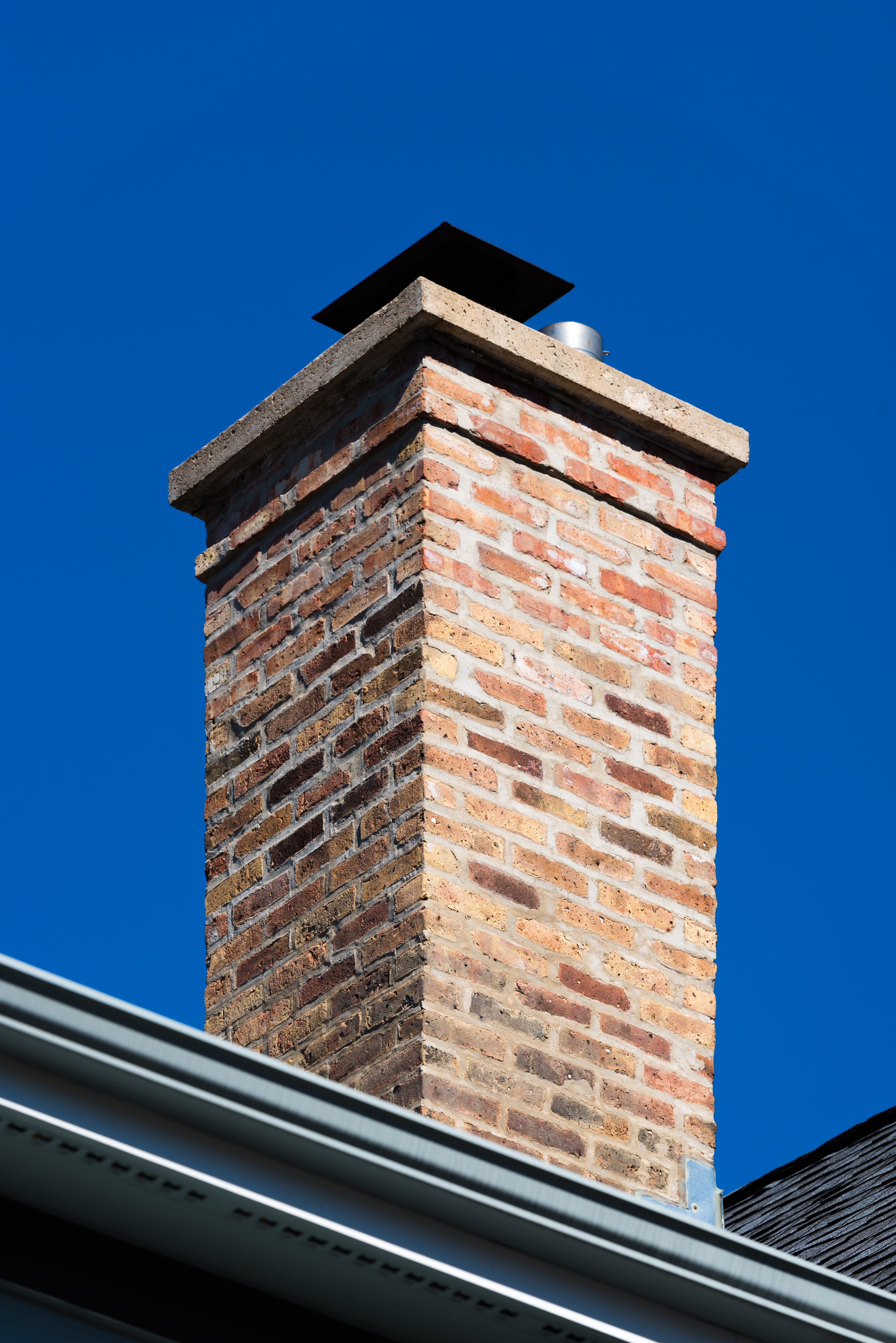 Red brick chimney stack close-up with lead flashing