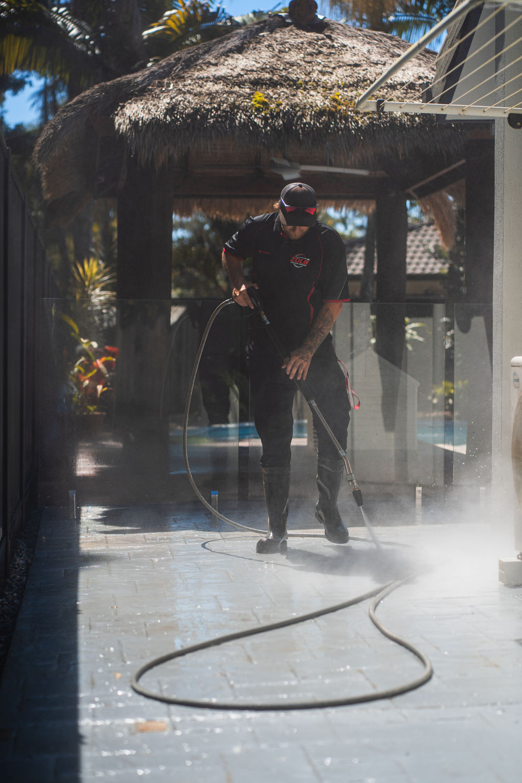 ZOLB technician pressure washing patio