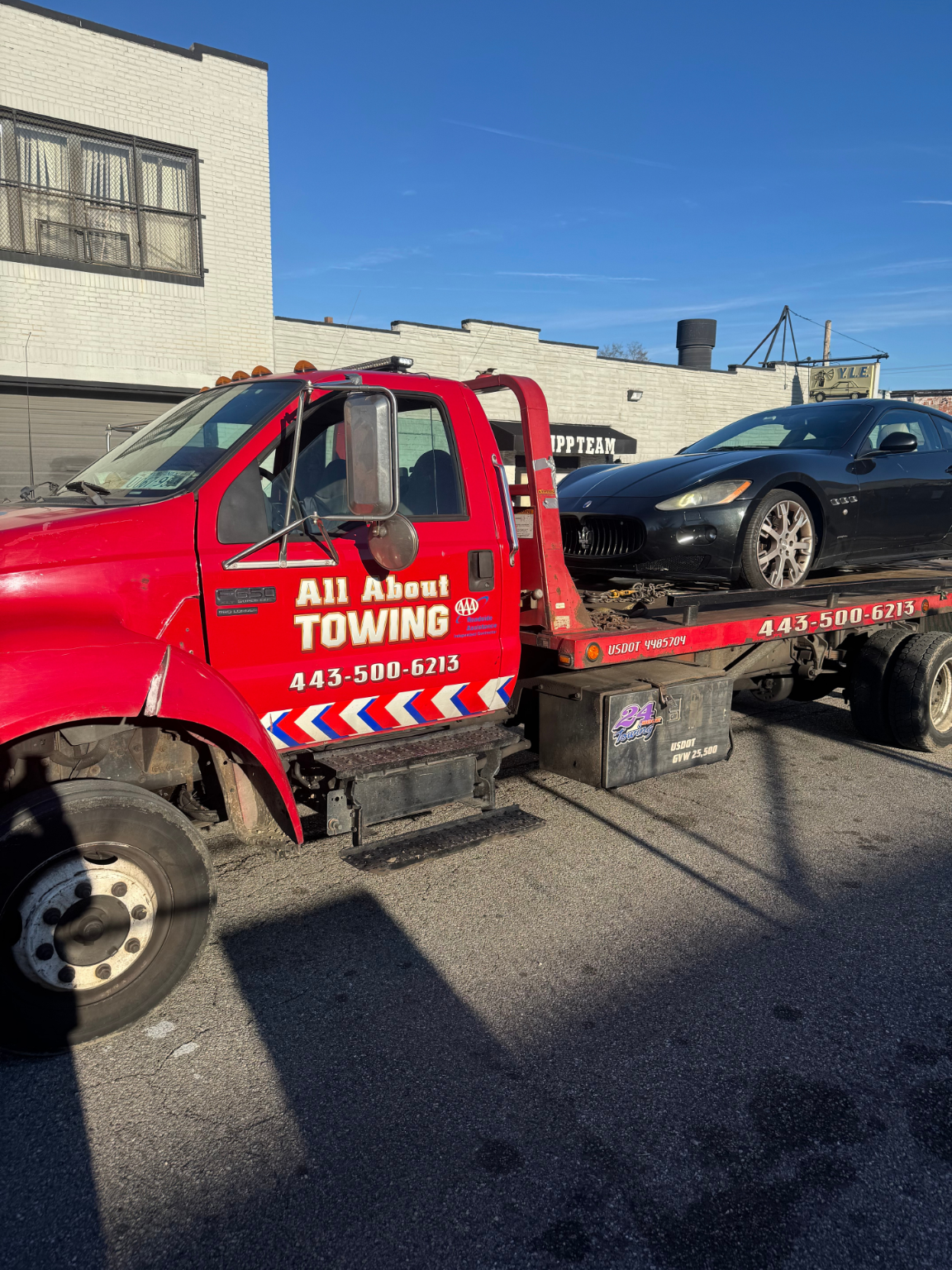 All About Towing red flatbed tow truck in Baltimore with USDOT 4985704 and phone number (443) 500-6213 on the side