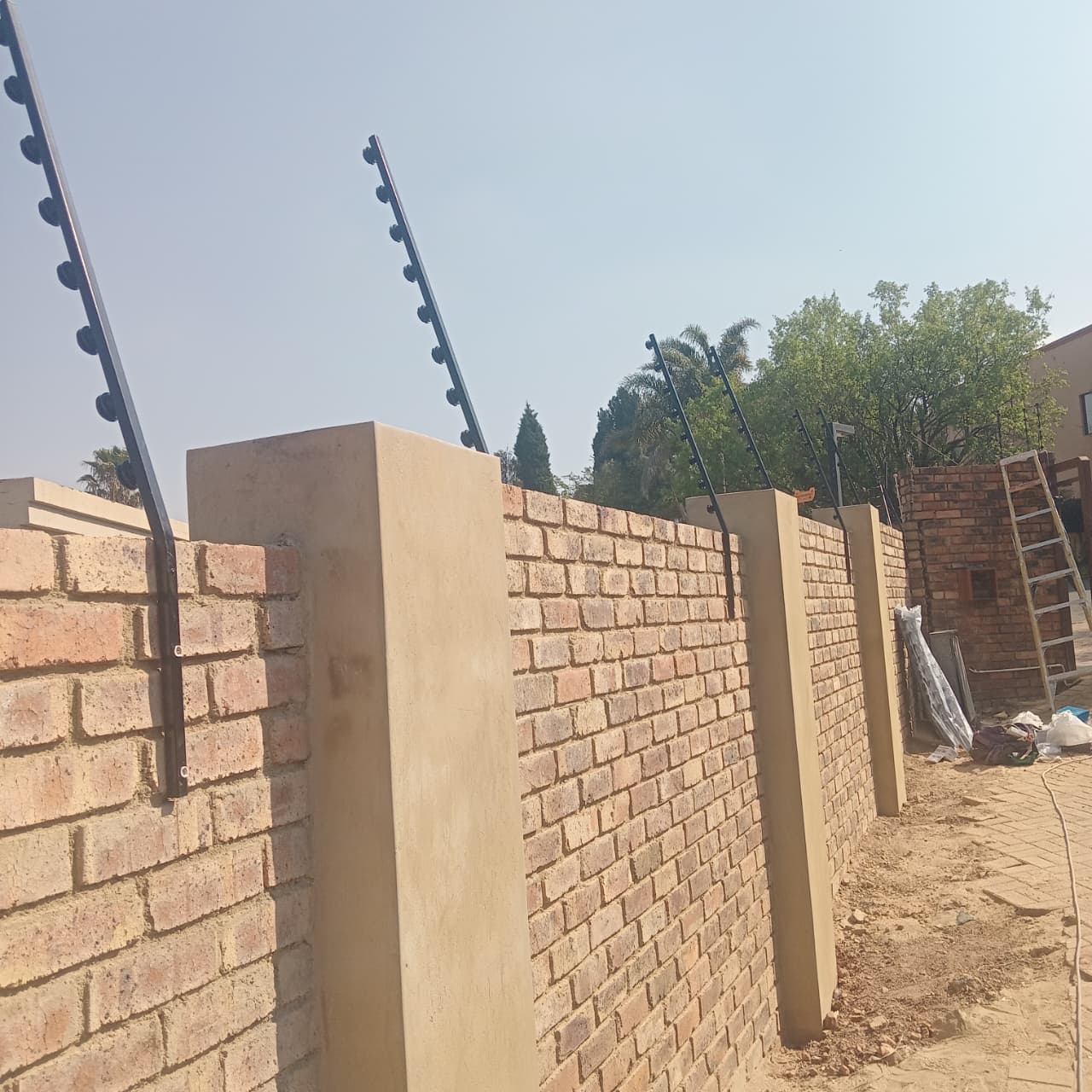 Brick boundary wall with electric fencing — building renovation in Northcliff