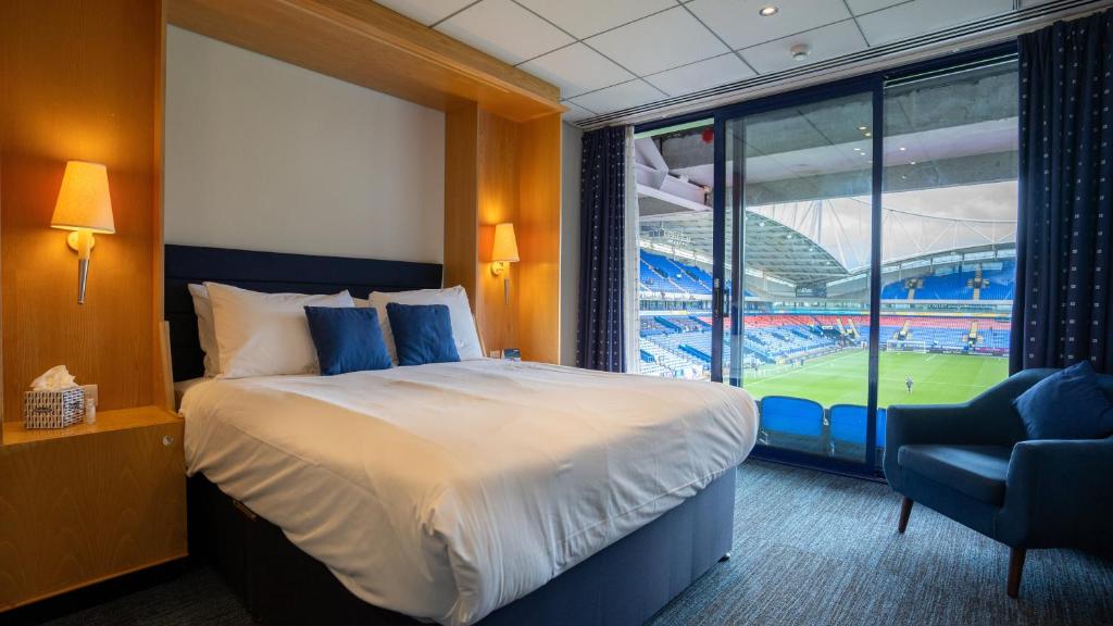 Modern hotel room with stadium view through floor-to-ceiling windows — quality Touchline tour accommodation
