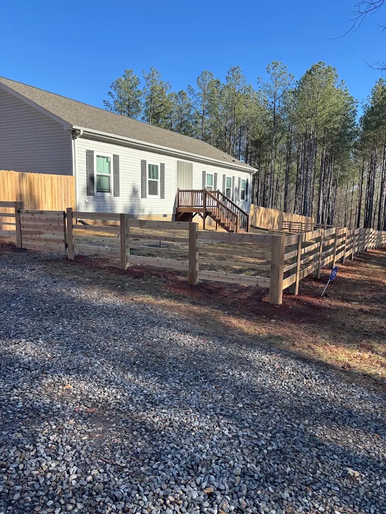 New horse fencing installed near a farmhouse for a Piedmont Triad client