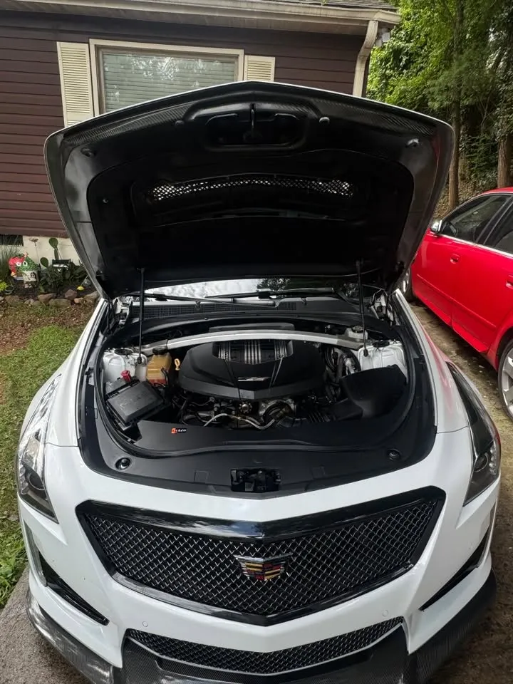 White Cadillac with immaculately detailed engine bay after comprehensive detail service