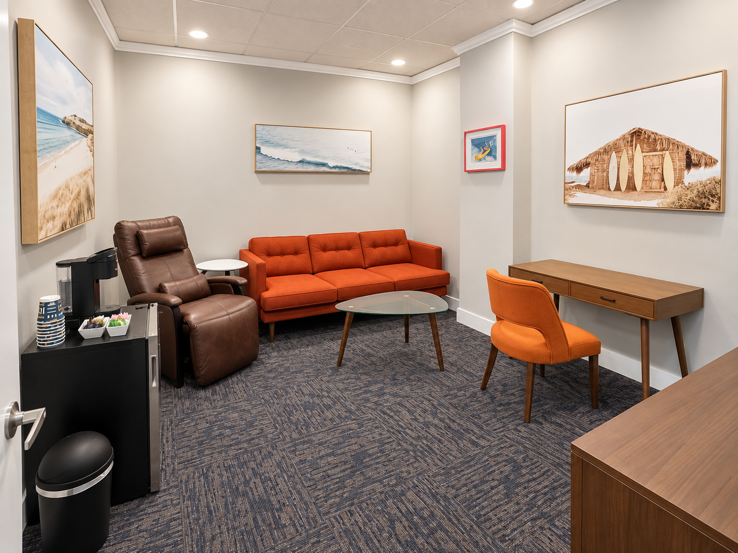 Private lounge suite with orange sofa, executive workstation, and kitchen amenities
