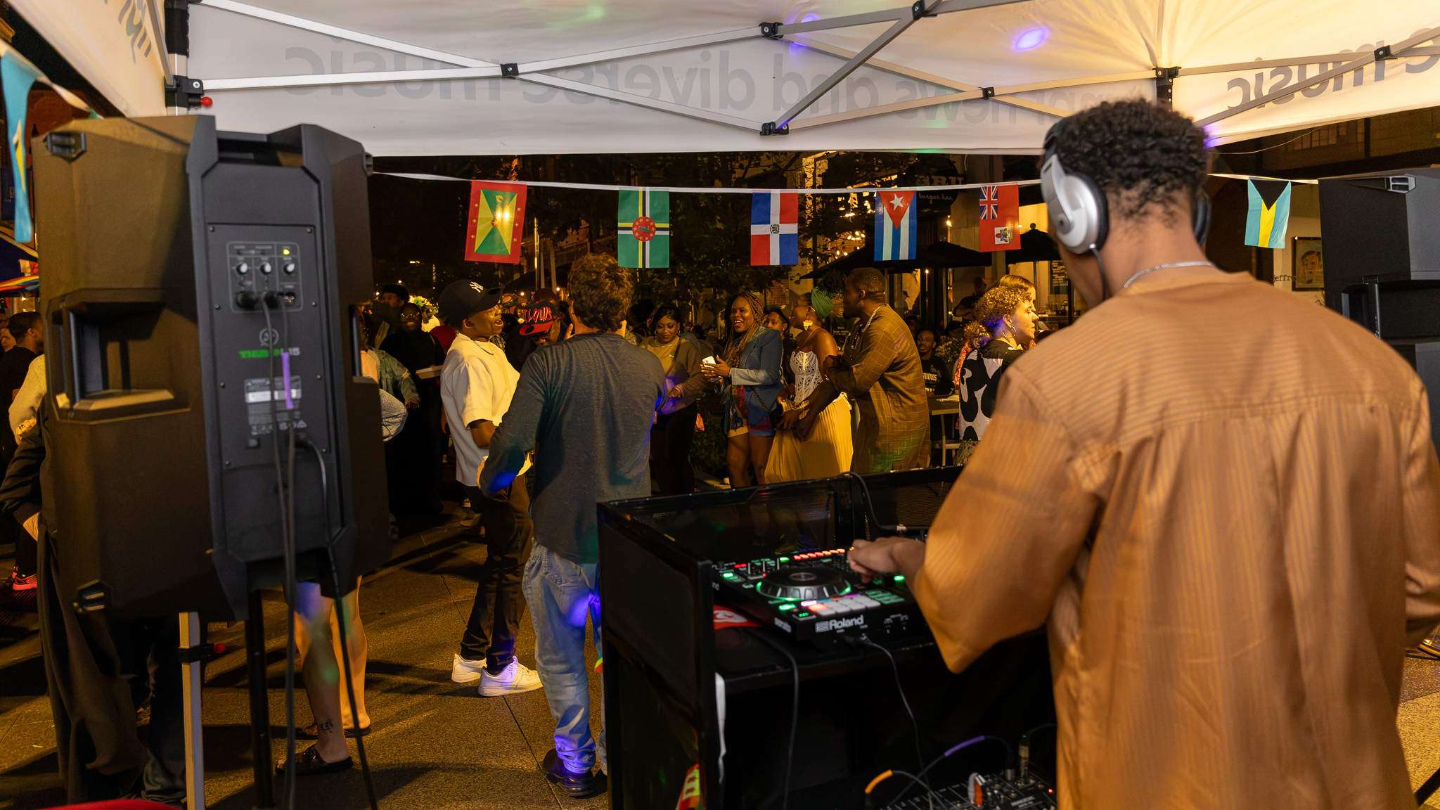 DJ performing at Taste of Africa with colorful lights on The Landing