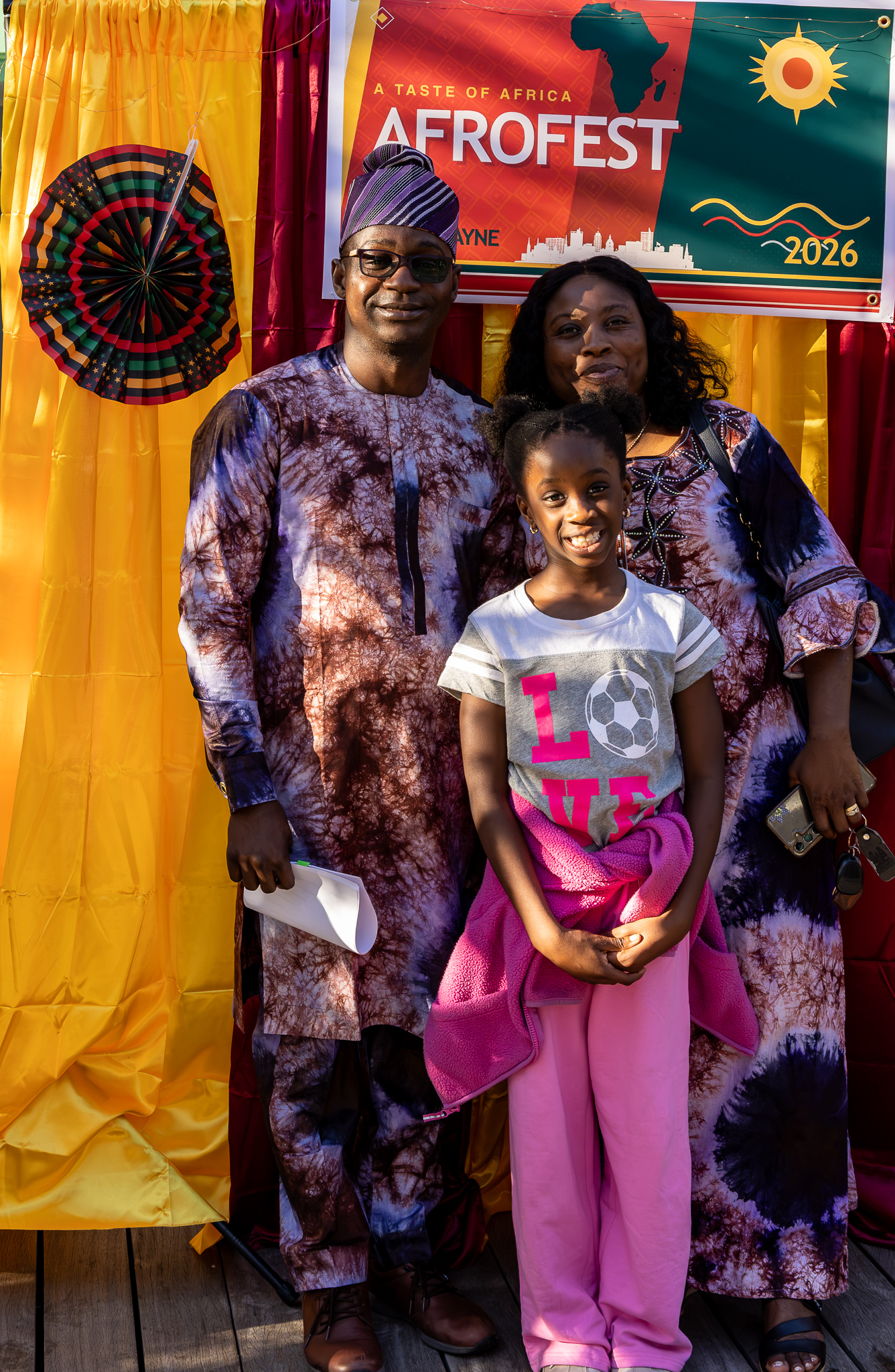 Family dressed in matching patterned attire at the Afrofest 2026 backdrop