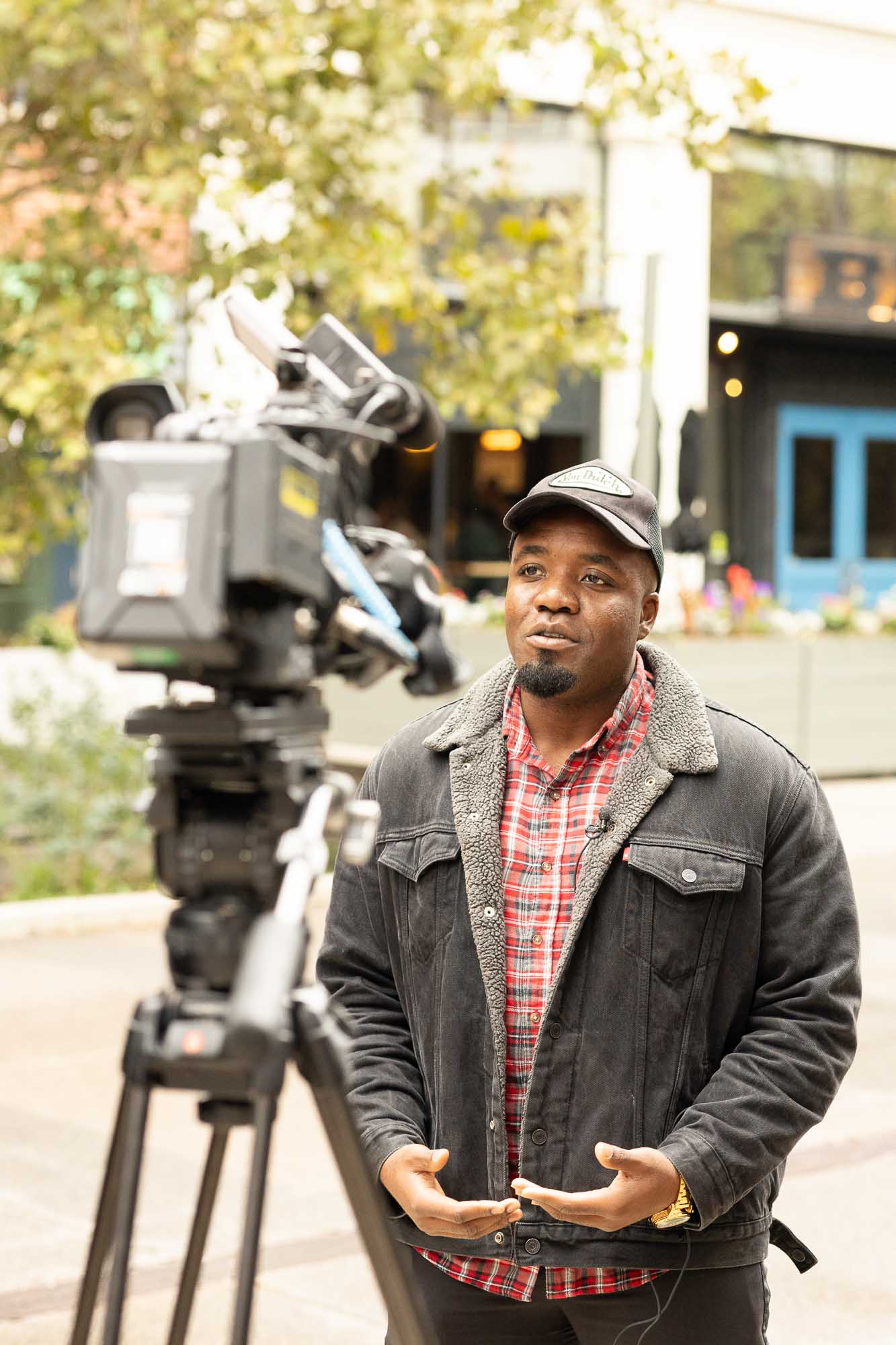 Portrait of Victor Inwang speaking in front of the TV camera