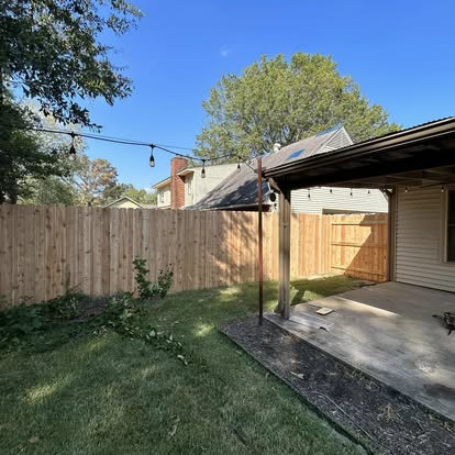 Finished cedar board privacy fence along covered back patio addition