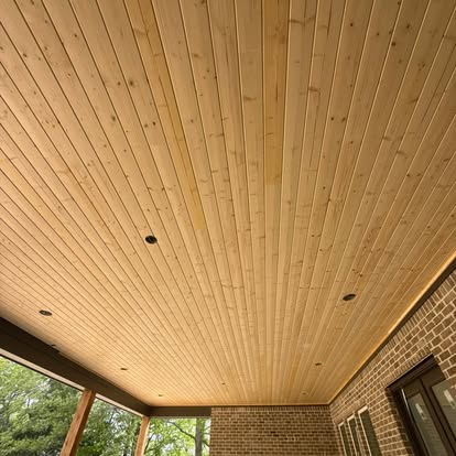 Natural tongue and groove wood porch ceiling with recessed lighting on covered patio