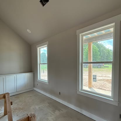 Finished indoor living addition overlooking covered outdoor deck and cedar porch posts