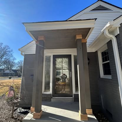 Front porch entrance with custom square wood posts, cedar trim, and beadboard ceiling
