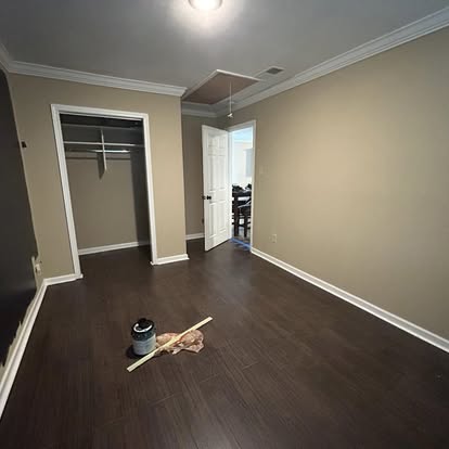 Freshly trimmed interior room with custom crown molding, baseboards, and closet framing