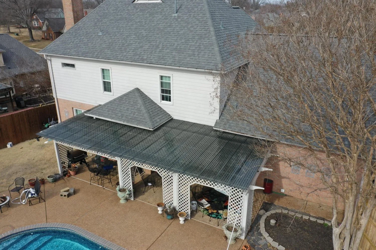 Aerial view of poolside covered pergola and outdoor living patio structure