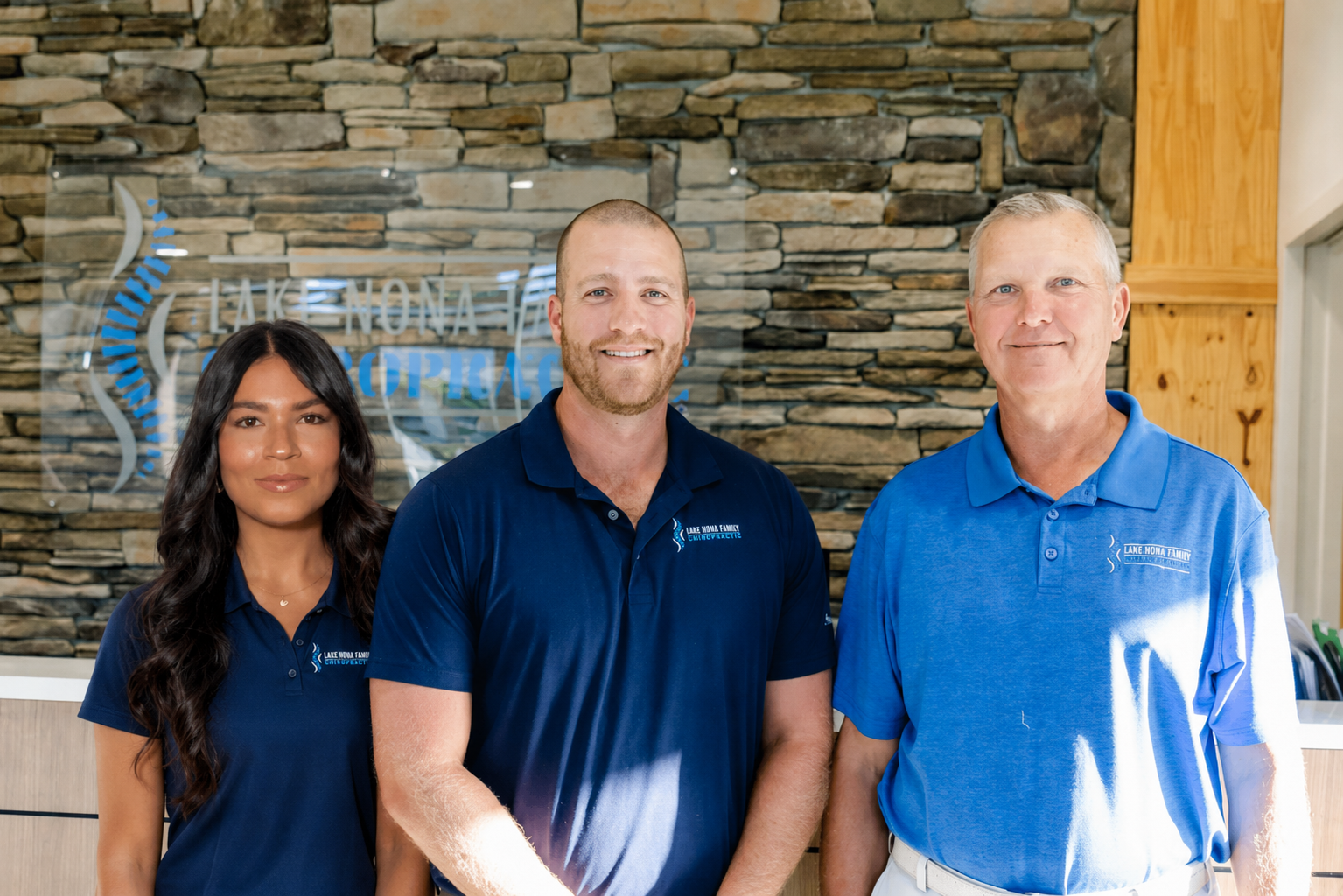The three doctors at Lake Nona Chiropractic: Dr. Adriana Diaz Franquiz, Dr. Frank Berzanskis Jr., and Dr. Frank Berzanskis Sr.