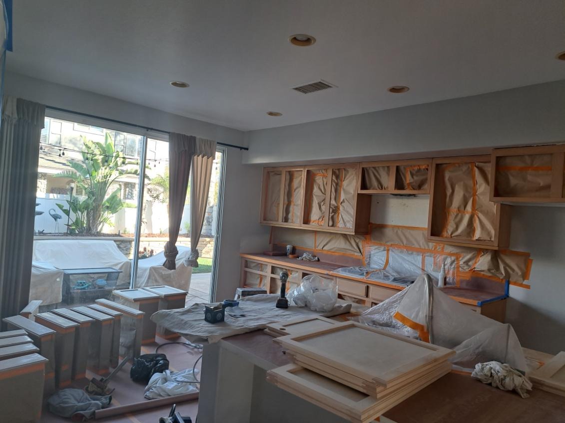 Mid-project view of our cabinet refinishing process. Every surface carefully masked and prepared for a professional finish.