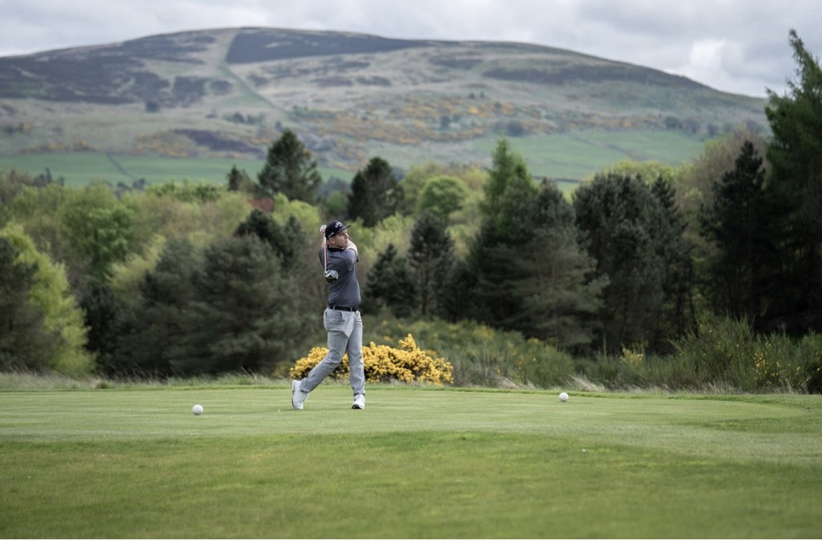 Paddy McKenna swinging on course with Scottish hills in the background