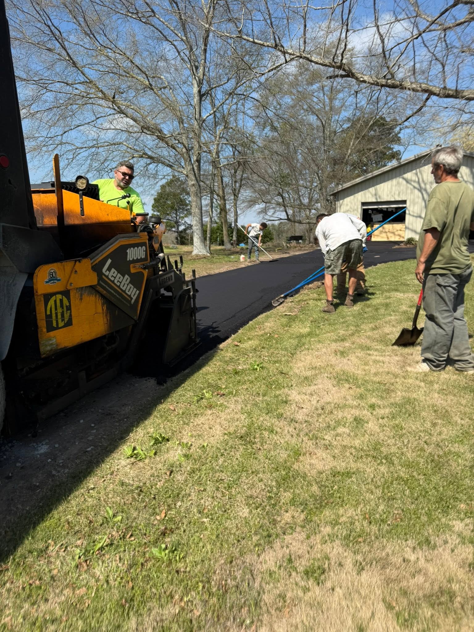 Hot-mix asphalt being applied during a paving project in North Alabama