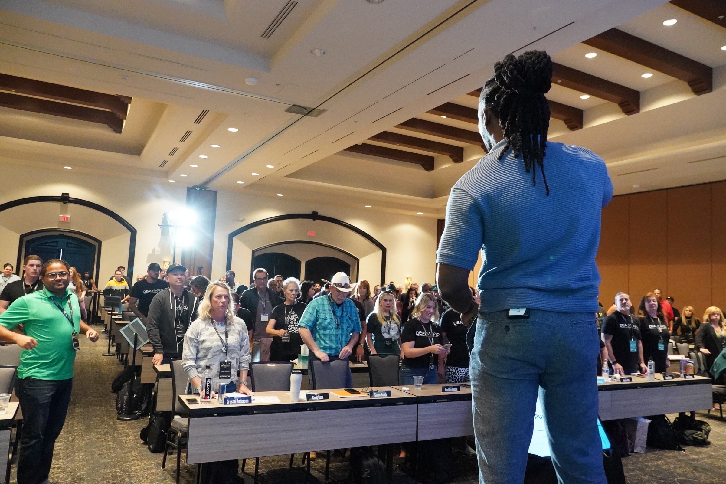 Keston speaking to an audience from a stage.