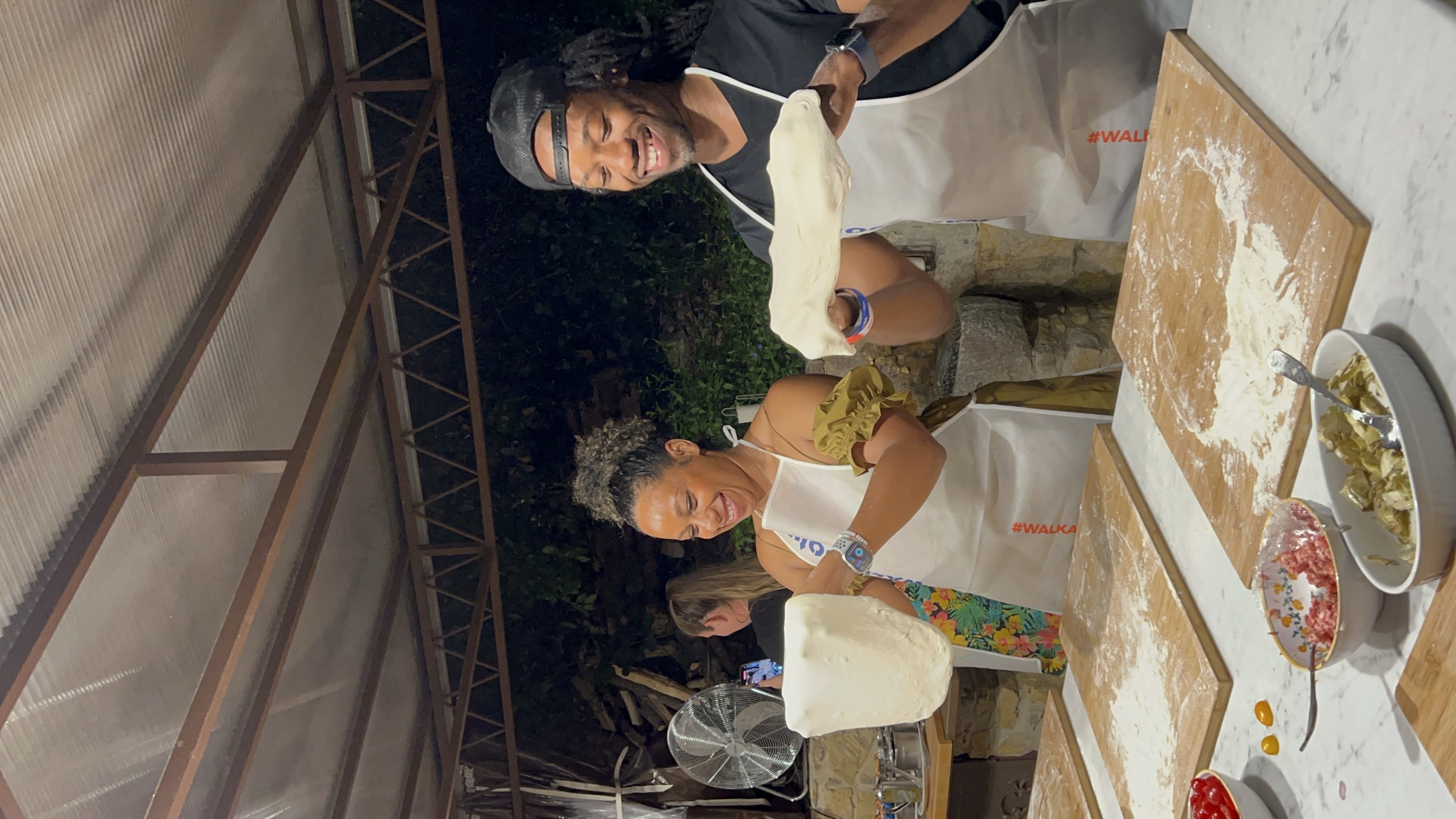 Kes and Jaz laughing while cooking and practicing something together.