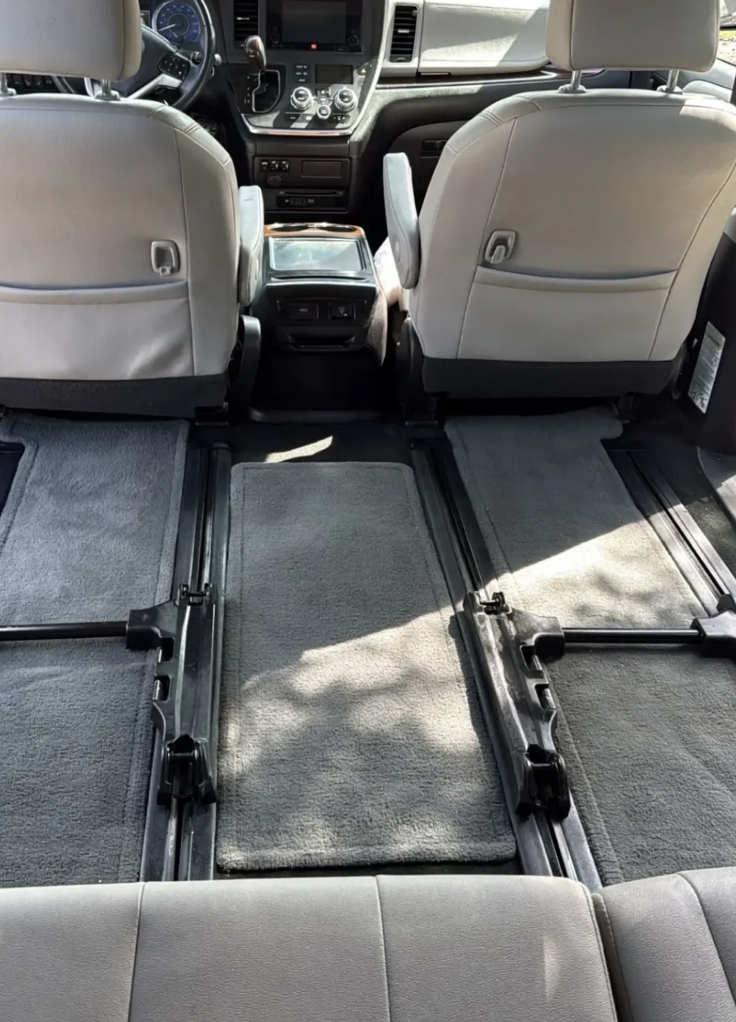 Spotless minivan interior with clean carpets, sanitized seat tracks, and refreshed seating after detailing