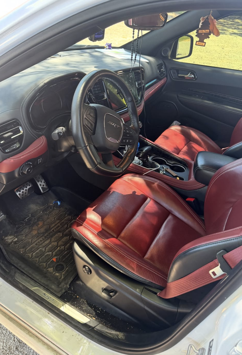 Dusty Dodge Challenger SRT interior with dirty floor mats, cluttered console, and grimy surfaces before mobile detailing in Savannah