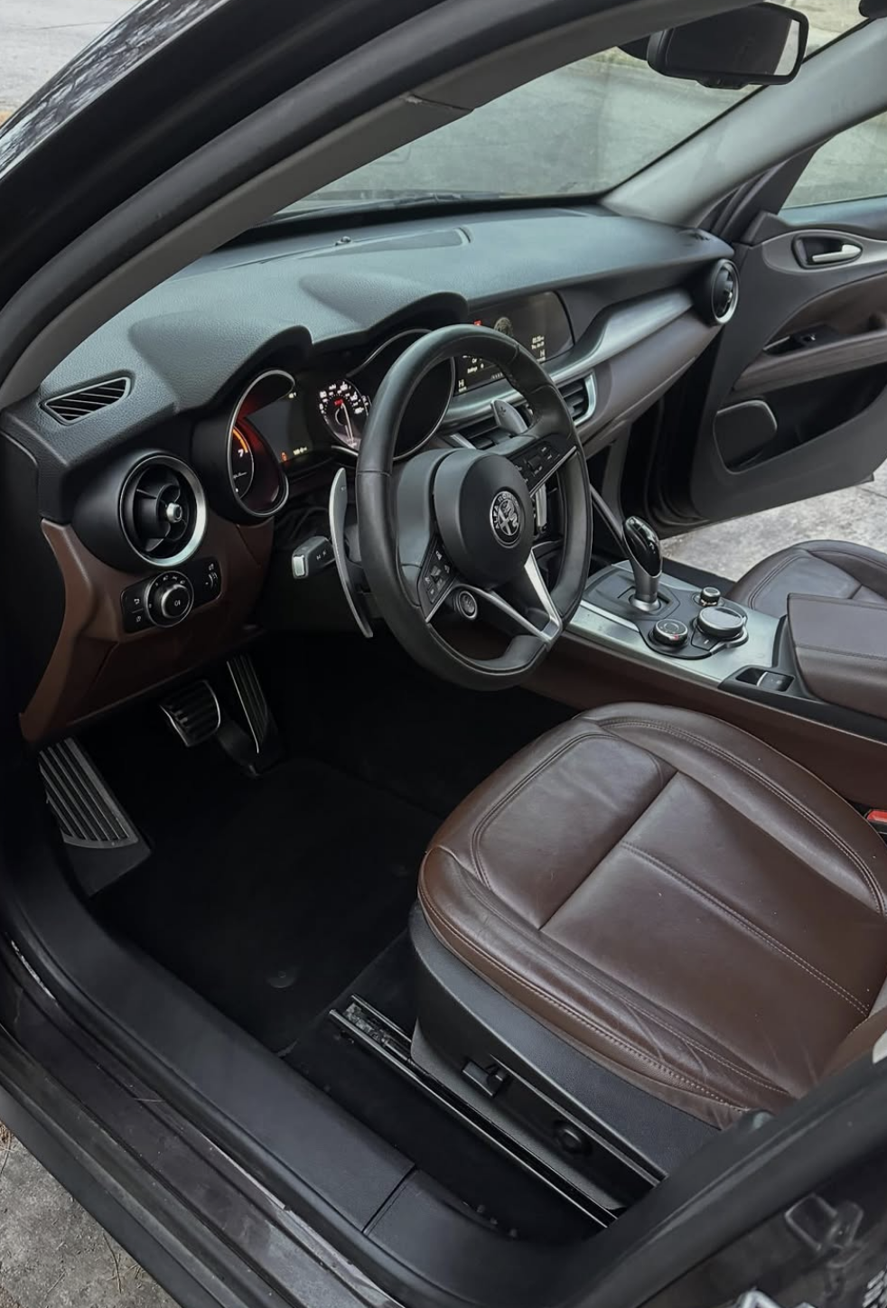 Clean detailed Alfa Romeo interior with refreshed leather seats, pristine dashboard, and spotless floor mats after professional mobile detailing in Savannah