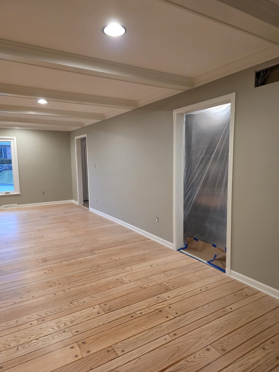 Room with plastic protection on door during professional paint prep