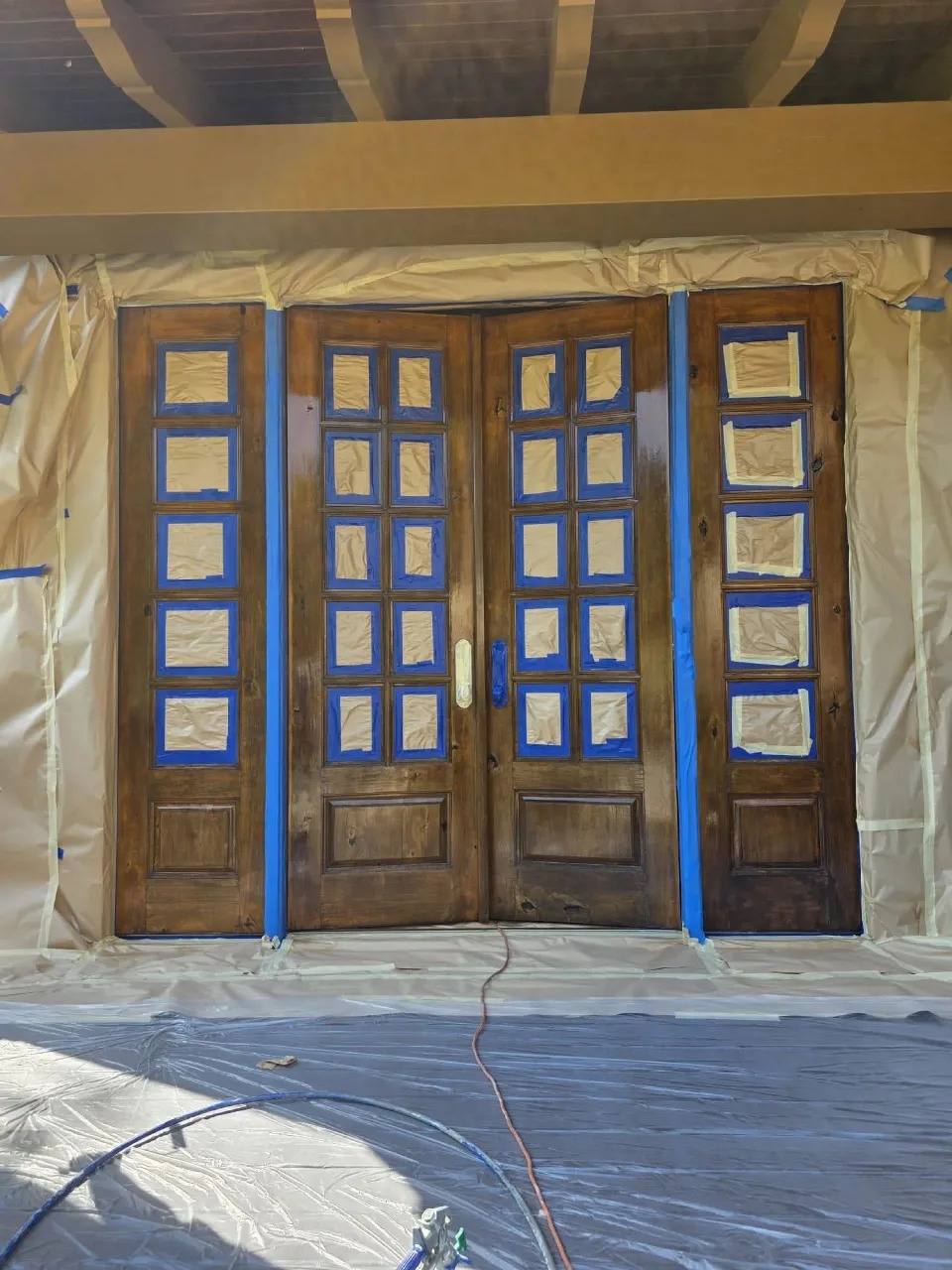 French doors fully prepped with blue painters tape and protective paper masking ready for professional paint application