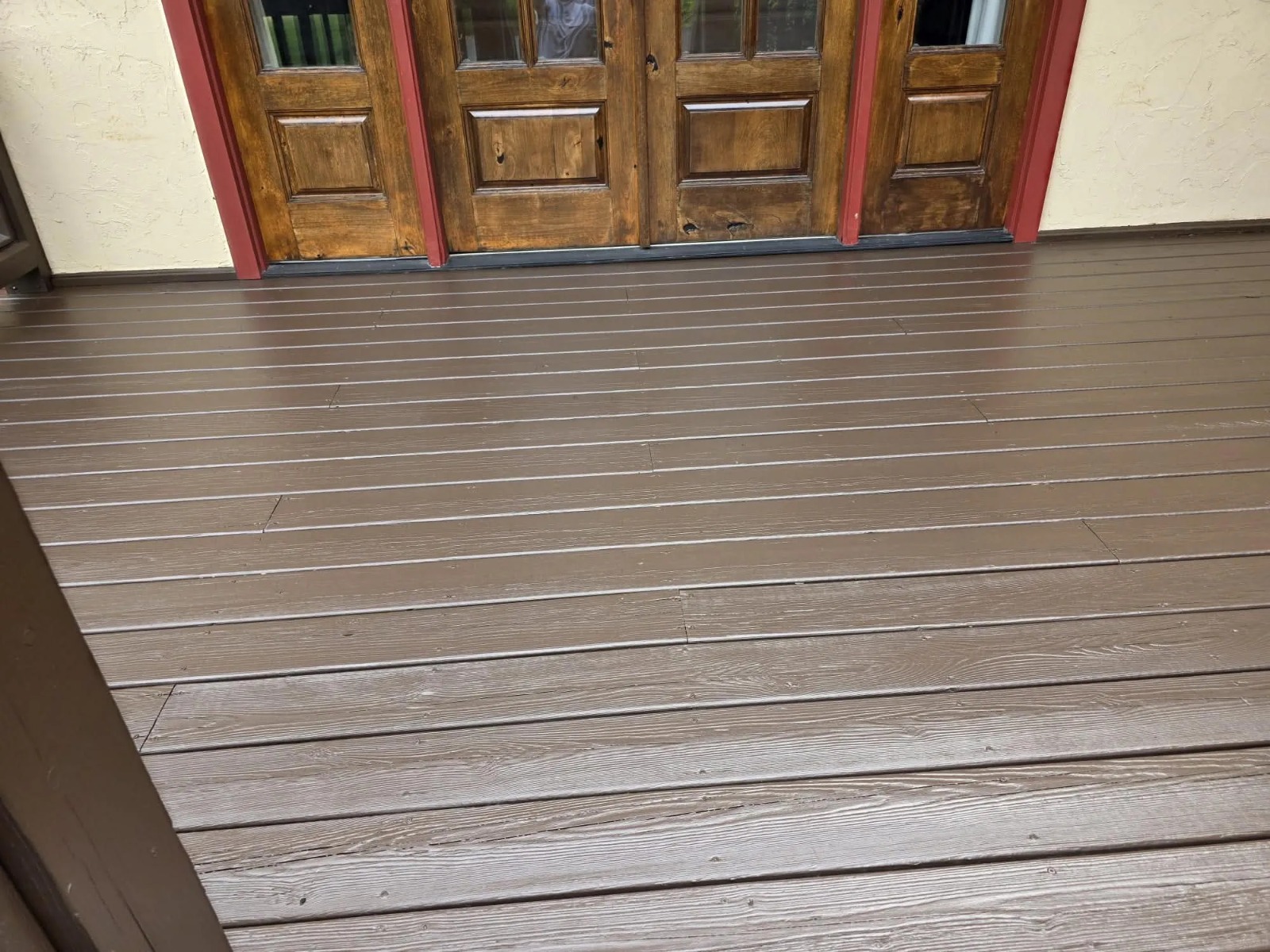Dark wood deck with French doors and burgundy red trim