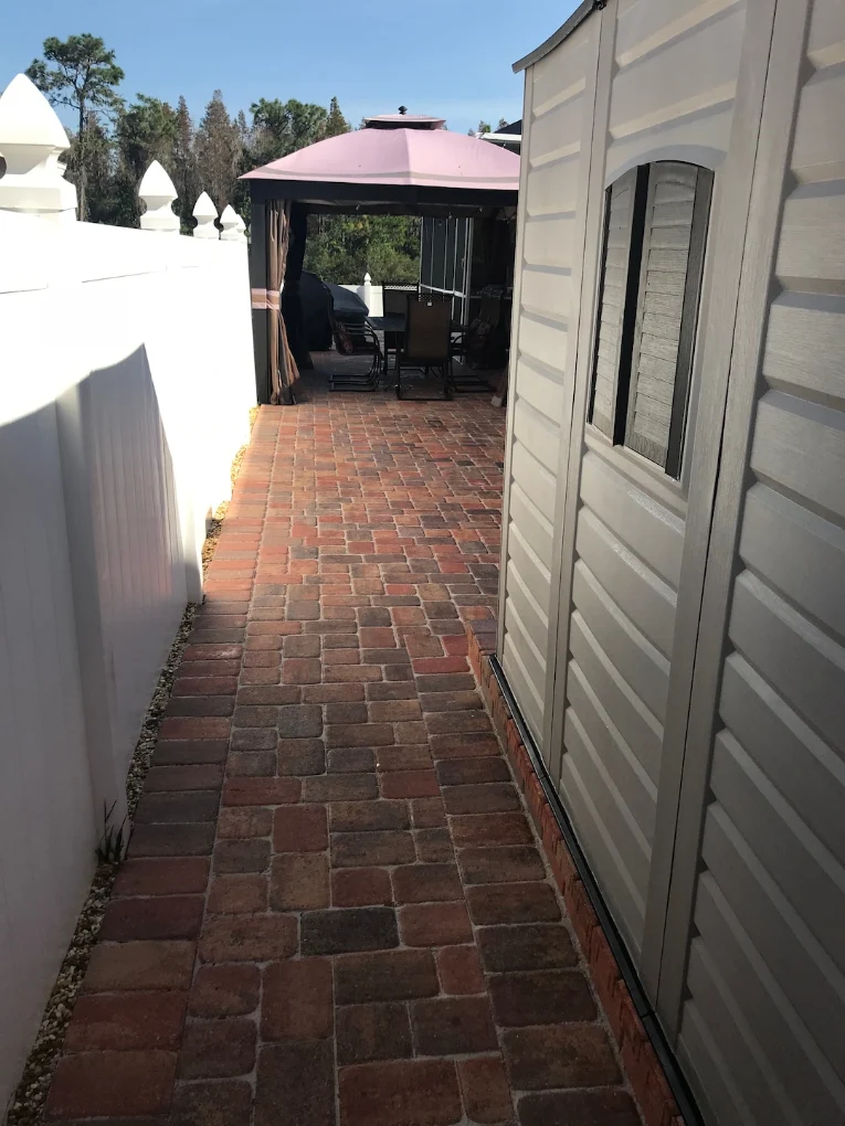 Red brick paver patio with outdoor seating area under canopy