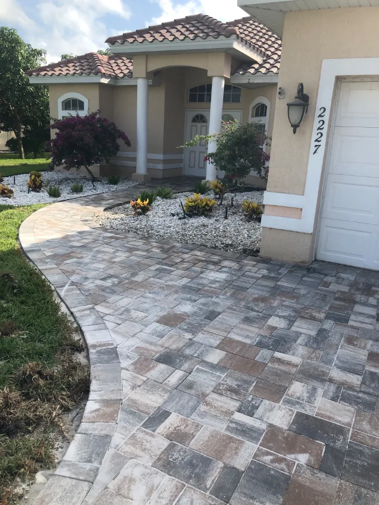 Curved paver walkway with landscaping and decorative rock bed