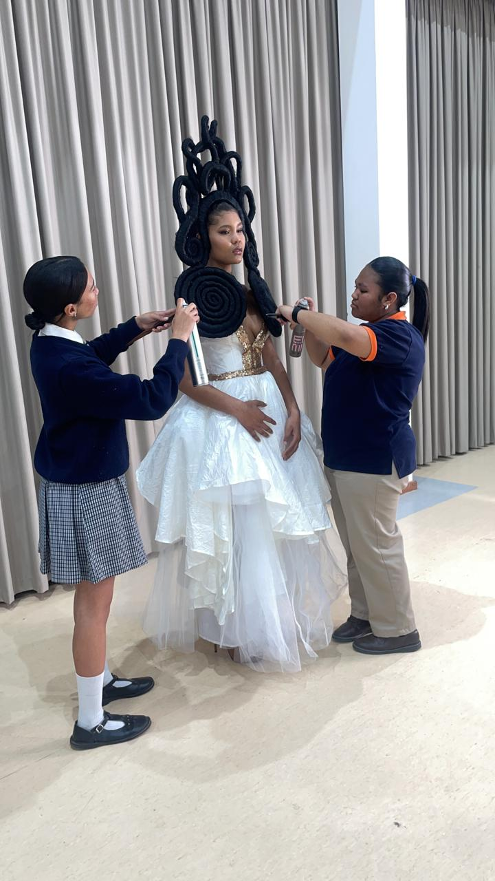 Students preparing a bridal look with elaborate updo styling