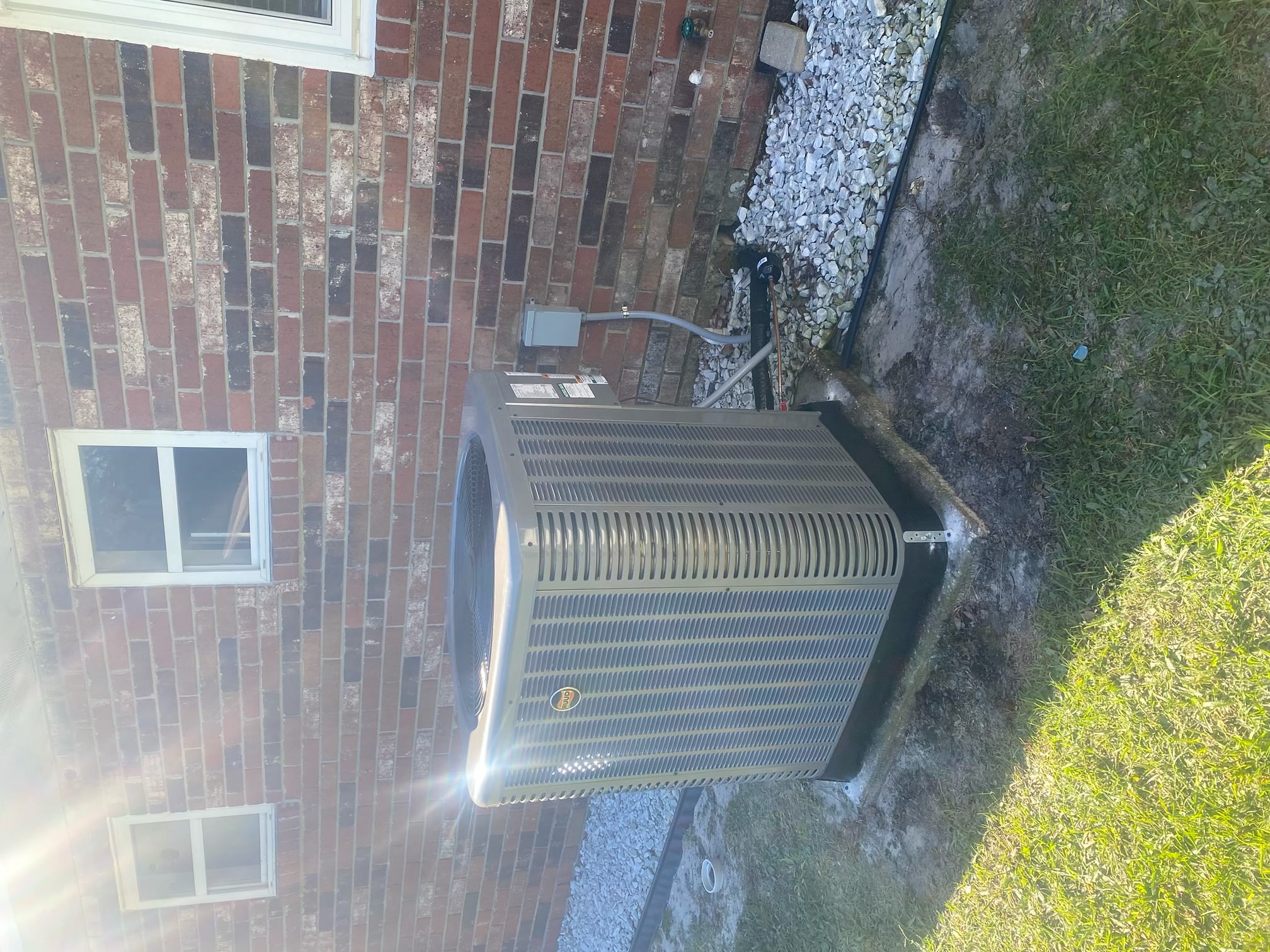 New Ruud 15 SEER2 two-speed heat pump installed outside a brick home in Williston, FL