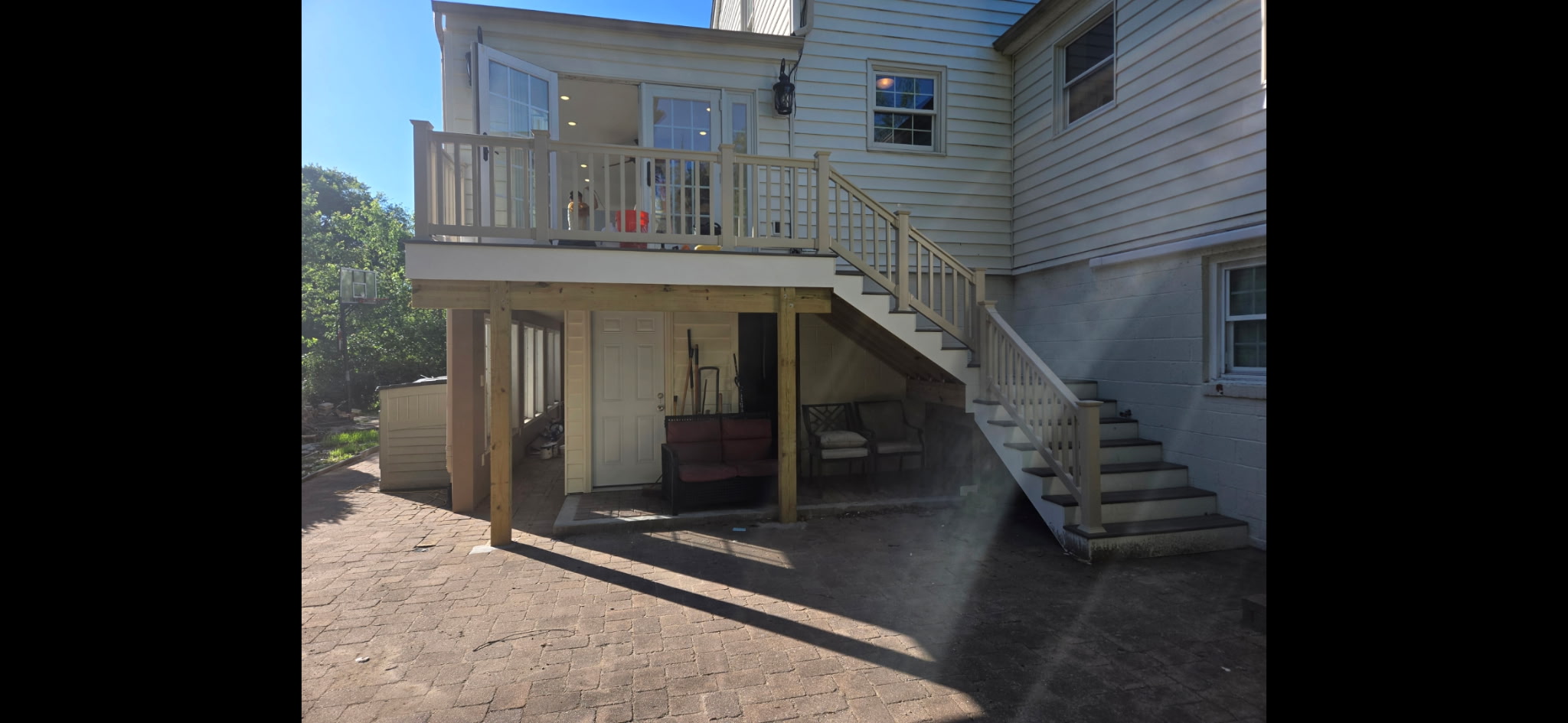 Two-level composite deck with vinyl railing and paver patio below