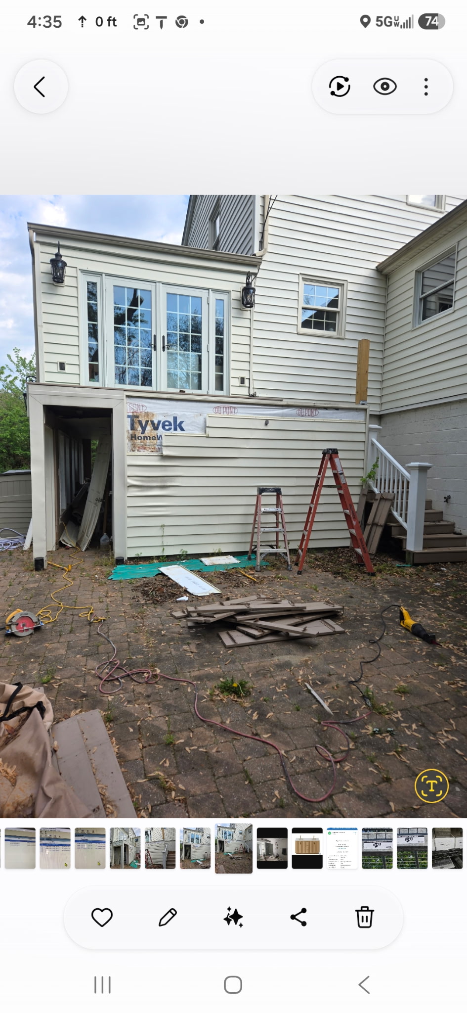 Home addition under construction showing Tyvek wrap, framing, and French doors on upper level