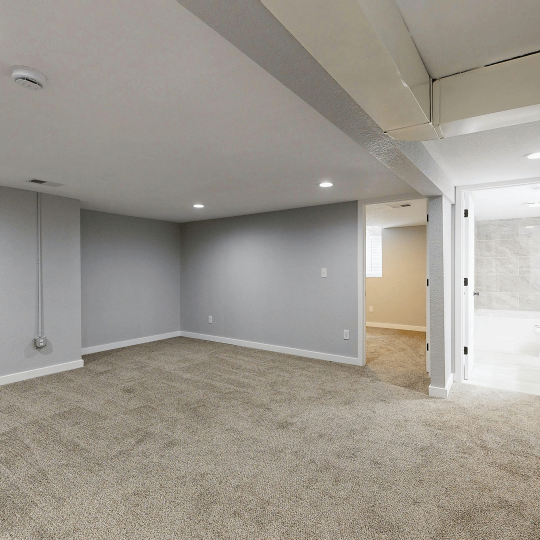 Carpeted finished basement room with blue-gray walls, recessed lighting, and doorway to adjacent spaces