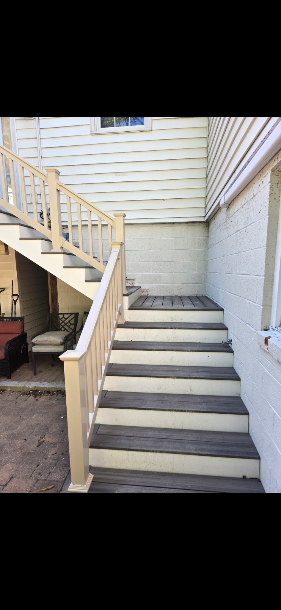 Composite deck stairs with vinyl railings and dark decking boards