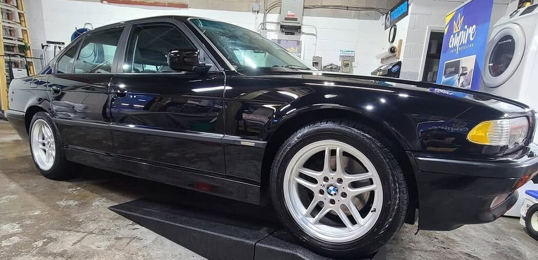 Black BMW sedan after premium detailing showing showroom-quality gloss