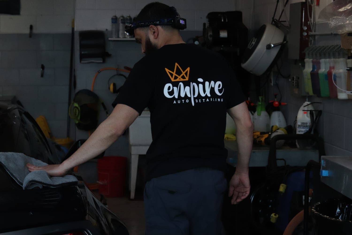 Empire detailer performing meticulous hand-detailing work on vehicle
