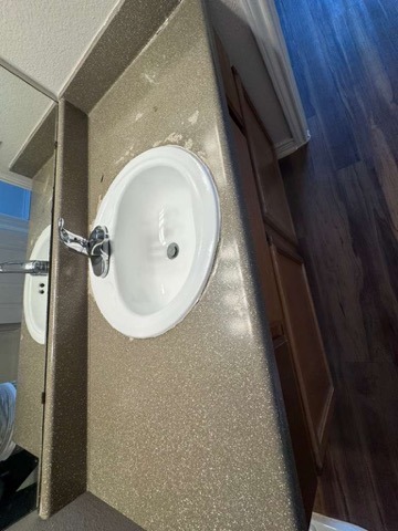 Modern bathroom vanity with round sink and speckled stone countertop