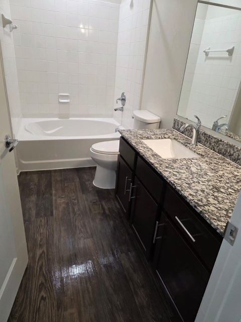 Bathroom after complete remodel - dark espresso cabinets, granite countertop, dark wood flooring and premium fixtures by Paint And Remodeling Aguilar LLC