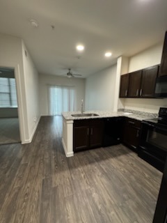Kitchen after complete remodel - dark espresso cabinets, granite countertops, luxury vinyl plank flooring and pristine finishes by Paint And Remodeling Aguilar LLC