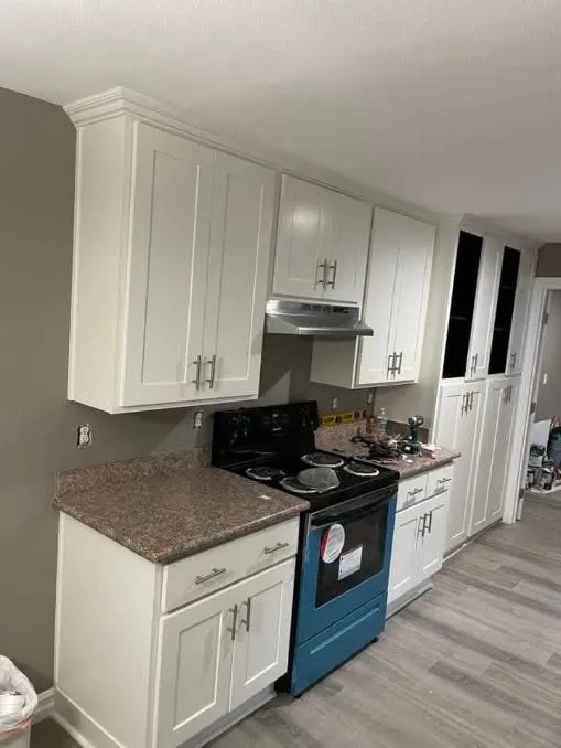 White shaker kitchen cabinets with striking blue oven and granite countertops in Mesa AZ