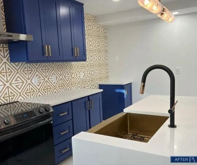 Navy blue kitchen cabinets with gold hardware and geometric pattern backsplash tile