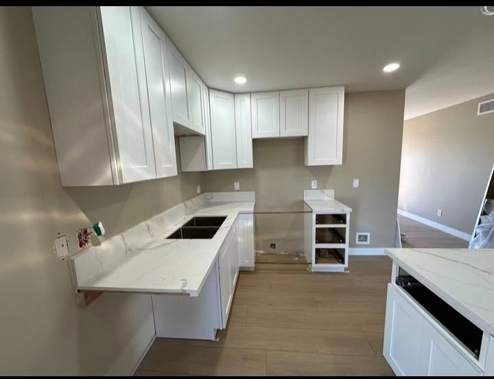 Complete kitchen renovation with crisp white cabinetry and warm neutral wall paint