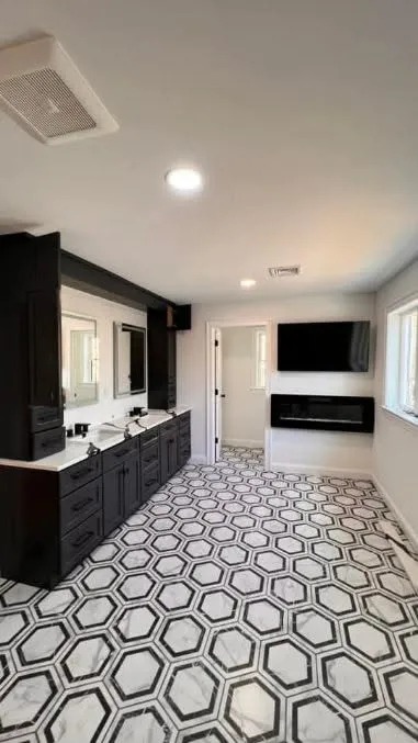 Black painted bathroom vanity cabinets with hexagon tile flooring and dual vessel sinks