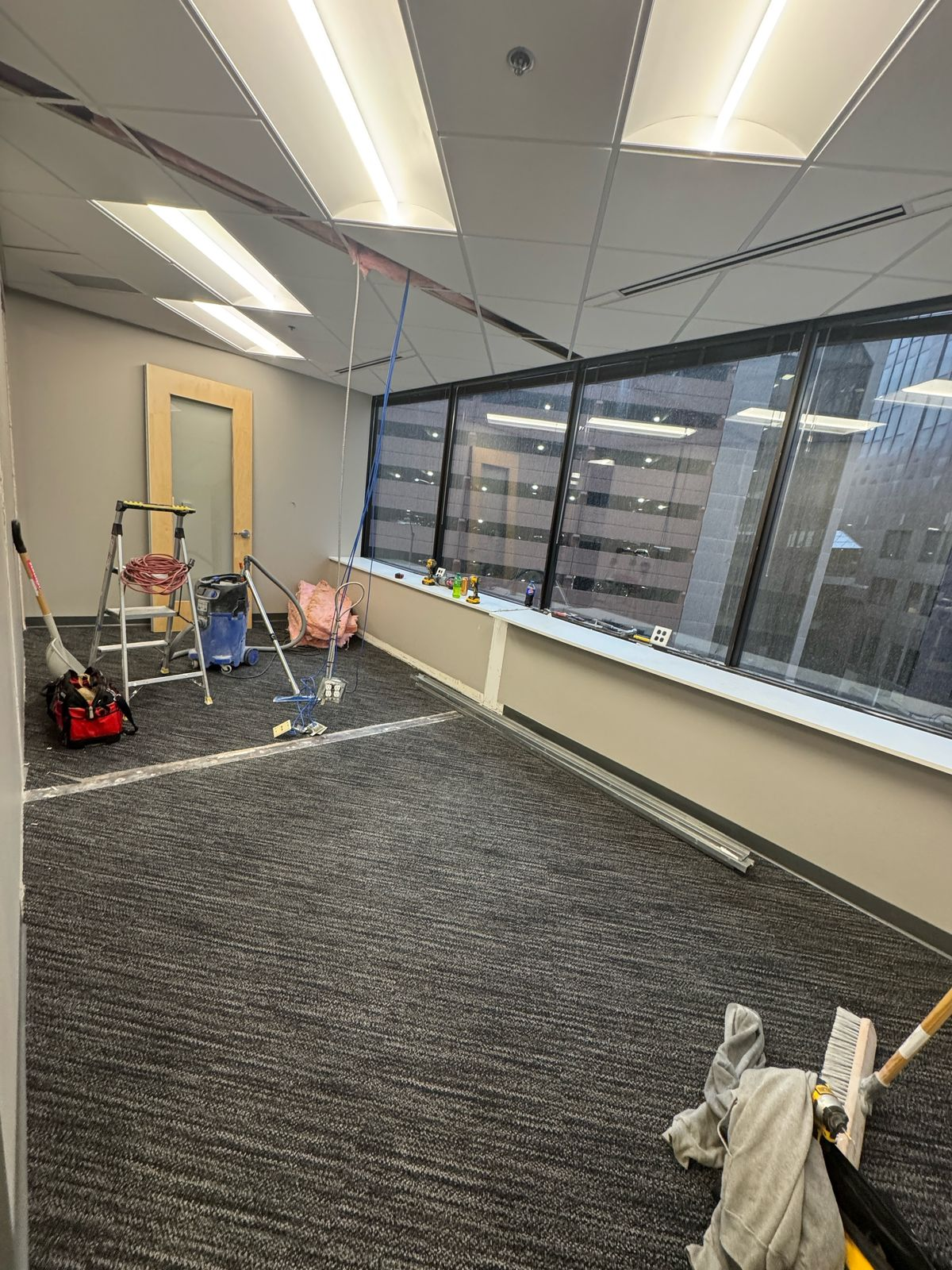 Post-construction cleaning of office with tools and equipment visible