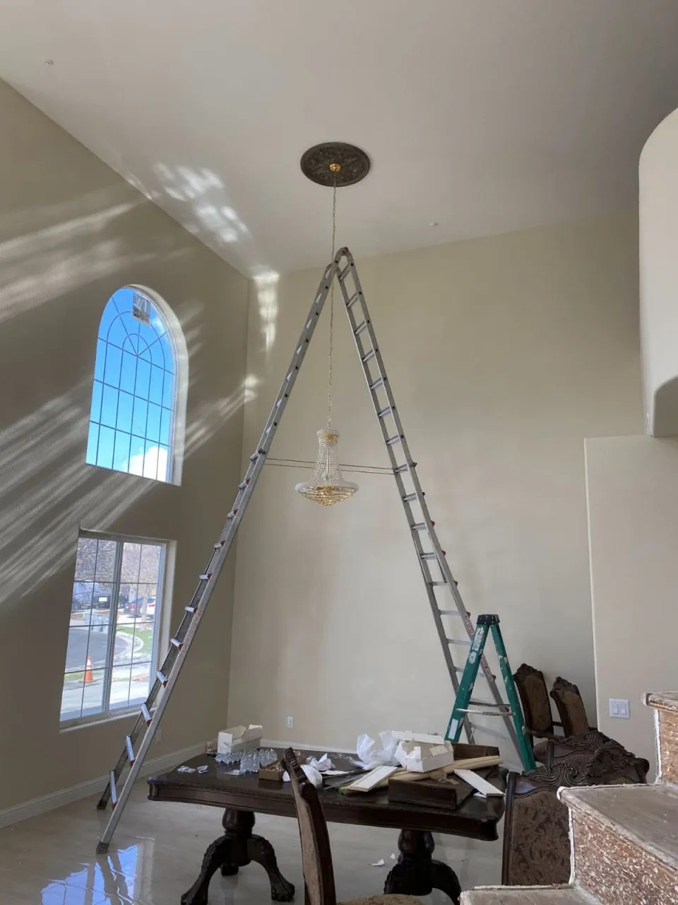 Professional Electrician Installing Crystal Chandelier in Sacramento Home