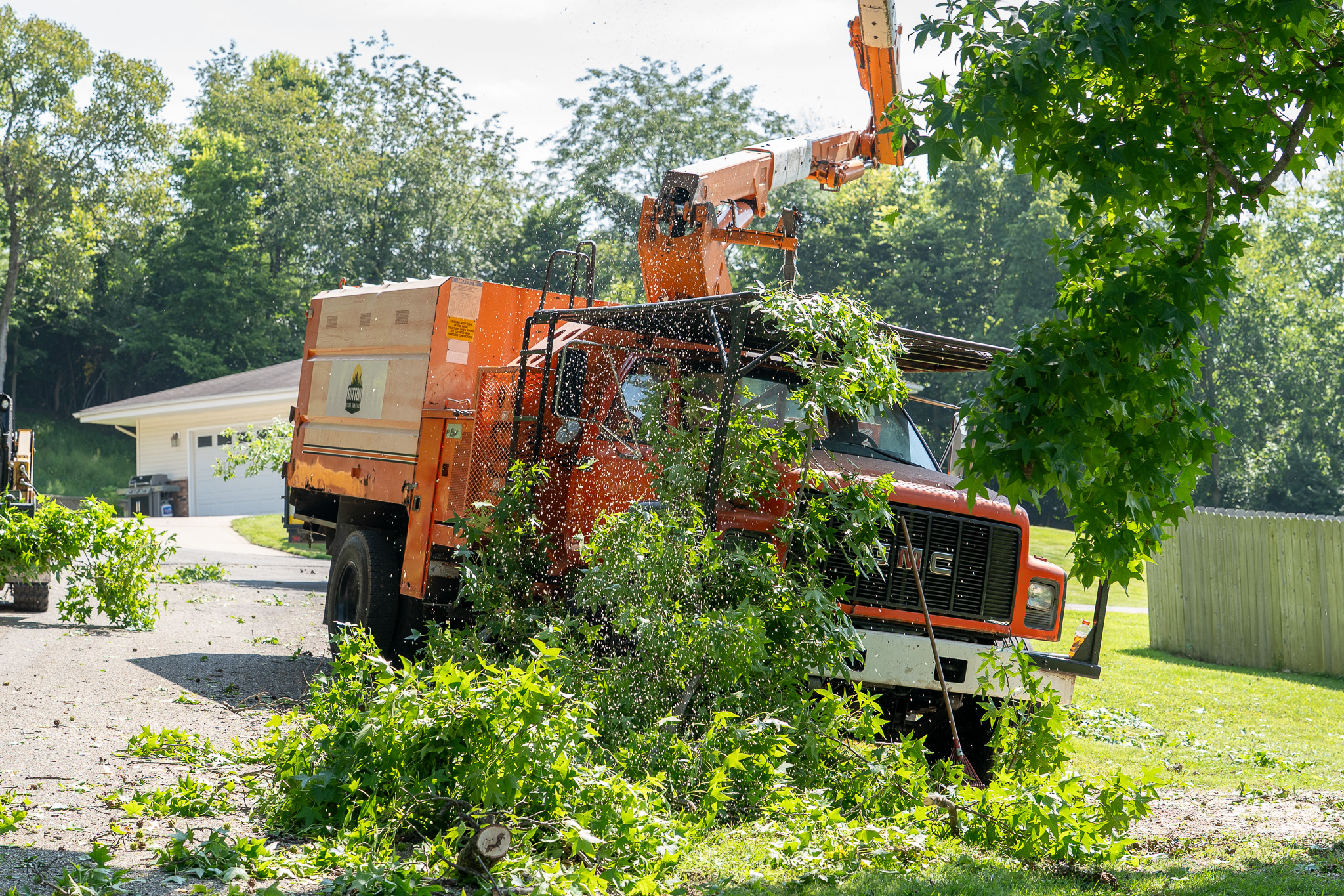 Sutton chipper truck processing branches and brush on site in Chandlerville Illinois