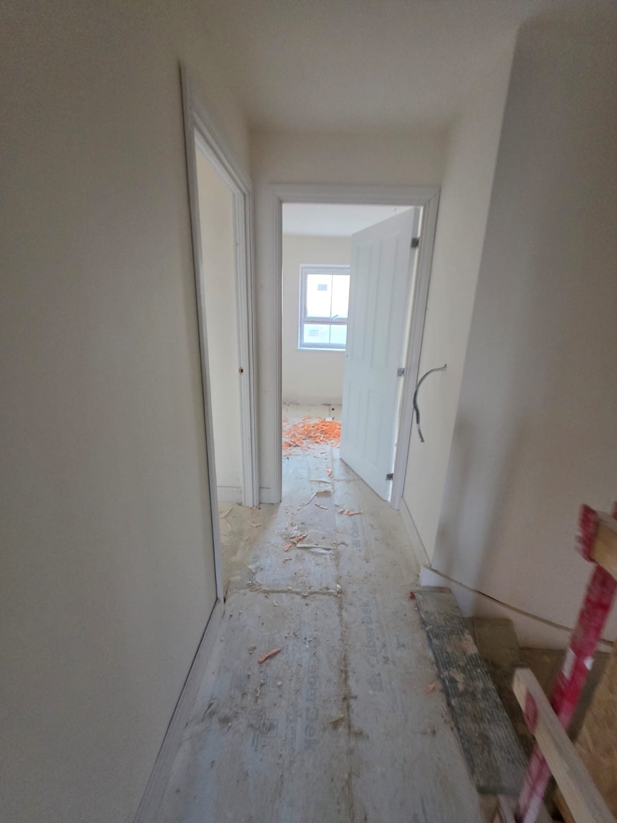 Upper hallway perspective showing hung internal doors, architraves and window carpentry in Harlow homes by DWELLUX